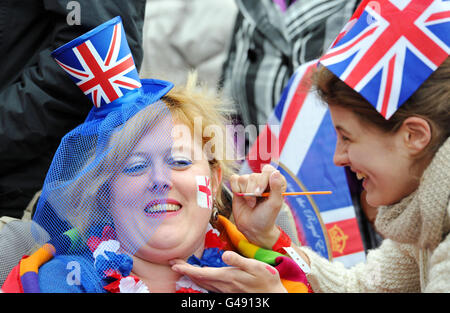 Phoebe Topping from Oxfordshire paints the face of Charlie Lancaster in the crowd waiting in Parliament Square, London, ahead of the wedding of Prince William and Kate Middleton. Stock Photo