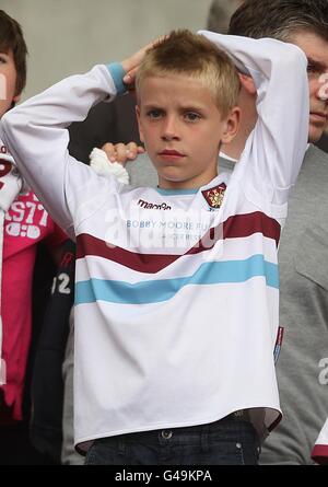 A young West Ham United fan sits dejected in the stands Stock Photo