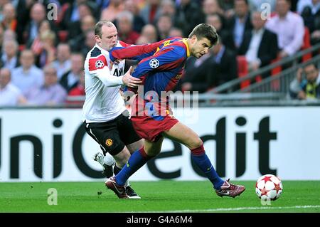 Soccer - UEFA Champions League - Final - Barcelona v Manchester United - Wembley Stadium. Manchester United's Wayne Rooney (left) and Barcelona's Gerard Pique battle for the ball Stock Photo