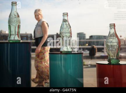 To help mark the 125th anniversary of Coca-Cola the Design Museum in London have put an exhibition in their Tank, outside the main building in Shad Thames including Coca-Cola's famour contour bottle and examples of their logo. It depicts the history of the famous drink and it's design icons. Stock Photo