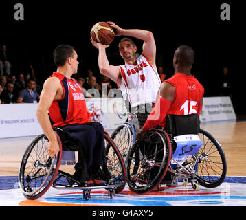 Canada's Adam Lancia takes on Great Britain's Matthew Sealy (left) and Ademola Orogbemi (right) during their Men's Wheelchair Basketball match during the Paralympic World Cup in Manchester. Stock Photo