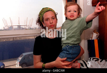 Six and a half months pregnant single mother Carolyne Rushton with her 22-month-old daughter Bertha, became a sitting tenant in the middle of the New Millennium Dome Experience at Greenwich after a successful plea to the Court of Appeal today (Monday). Carolyne is fighting attempts to evict her from the 19th Century gas worker's cottage, at River Way which overlooks the dome development (seen through the window) in south east London, where she has lived for more than 13 years. See PA Story COURTS Dome. Photo by Fiona Hanson/PA. Stock Photo