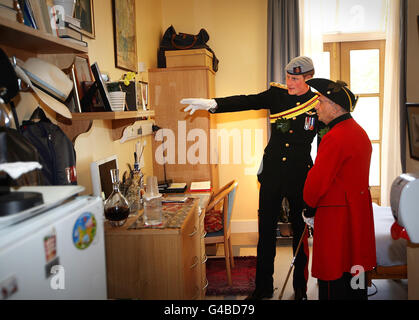 Prince Harry talks with In-Pensioner John Ley in his room at the Margaret Thatcher Infirmary at the Royal Hospital Chelsea in London, where he attended the annual Founder's Day Parade at the hospital for retired military personnel. Stock Photo