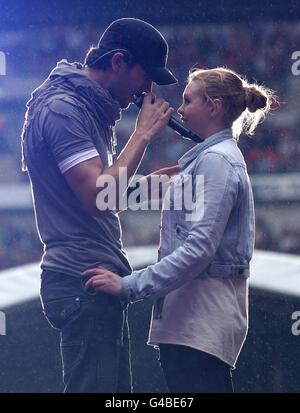 Enrique Iglesias sings to fan Sophie Elphick, 18, on stage during Capital FM's Summertime Ball at Wembley Stadium, London. Stock Photo