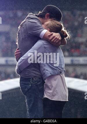 Enrique Iglesias hugs fan Sophie Elphick, 18, on stage during Capital FM's Summertime Ball at Wembley Stadium, London. Stock Photo