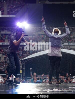 Enrique Iglesias sings to fan Sophie Elphick, 18, on stage during Capital FM's Summertime Ball at Wembley Stadium, London. Stock Photo