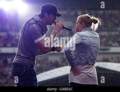 Enrique Iglesias sings to fan Sophie Elphick, 18, on stage during Capital FM's Summertime Ball at Wembley Stadium, London. Stock Photo