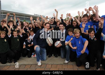 Dunblane High School held their own Rugby World Cup this week with teams representing the 7 nations as Scotland stars Johnny Beattie and Graeme Morrison (left) went along to present the trophy to winning team captain Jim Brownlee (centre) representing New Zealand, team pictured with all the kids taking part, during the World Cup photocall at Dunblane High School, Dunblane. Stock Photo