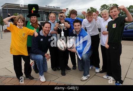 Dunblane High School held their own Rugby World Cup this week with teams representing the 7 nations as Scotland stars Johnny Beattie and Graeme Morrison (left) went along to present the trophy to winning team captain Jim Brownlee (centre) representing New Zealand, team pictured with all the kids taking part, during the World Cup photocall at Dunblane High School, Dunblane. Stock Photo