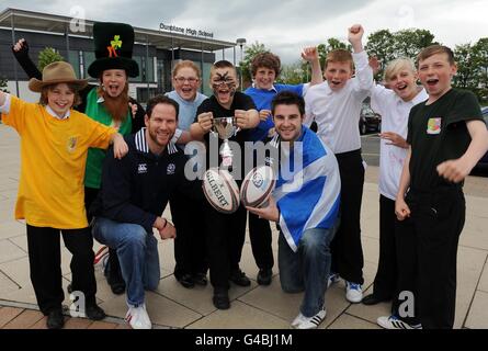 Dunblane High School held their own Rugby World Cup this week with teams representing the 7 nations as Scotland stars Johnny Beattie and Graeme Morrison (left) went along to present the trophy to winning team captain Jim Brownlee (centre) representing New Zealand, team pictured with all the kids taking part, during the World Cup photocall at Dunblane High School, Dunblane. Stock Photo