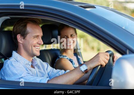 MODEL RELEASED. Couple driving in car, smiling. Stock Photo