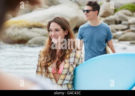 MODEL RELEASED. Young woman on beach with surfboard. Stock Photo