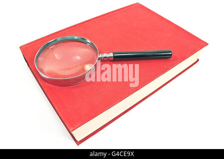 Antique magnifying glass on red book isolated on white Stock Photo