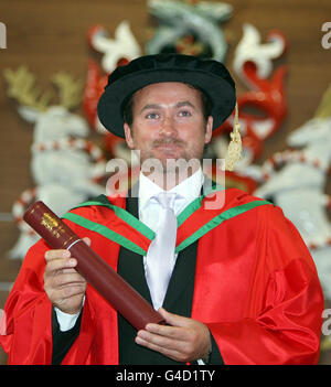 Former US Open golf champion Graeme McDowell holds his honorary doctorate of science degree presented to him by actor and Chancellor of the University of Ulster, Dr James Nesbitt, at a graduation ceremony at the university. Stock Photo