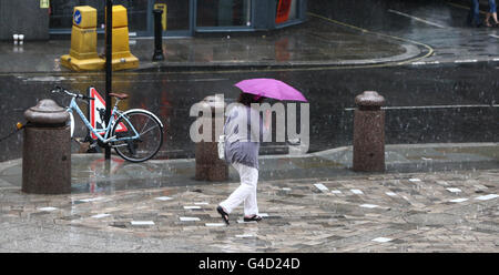 A woman walks through the rain outside St Paul's Cathedral in London, as parts of the country are bracing themselves for flash flooding. Stock Photo