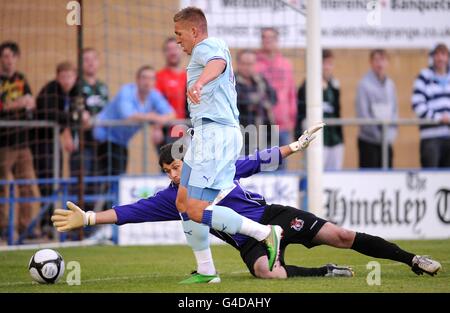 Soccer - Pre Season Friendly - Hinckley United v Coventry City - Greene King Stadium. Coventry City's Freddie Eastwood rounds Hinckley United goalkeeper Dan Haystead to score his side's second goal of the game Stock Photo
