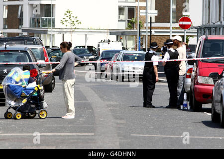 A general view of police at the scene on Banning Street in Greenwich, south-east London, where a man was shot in the head last night. Stock Photo