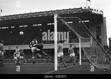 Manchester City goalkeeper Ken Mulhearn collides with Arsenal's Bobby Gould as Glyn Pardoe (3) and Dave Connor guard the Manchester City goal line. tips the ball over the cross bar to save from Arsenal's Bobby Gould (c). Arsenal's David Jenkins (behind goalpost) in following up. Stock Photo