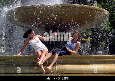 Vicky Woodcock (left) and Nicola Wilden from Essex splash around in the fountains in Trafalgar Square, in London, on one of the hottest days of the year as temperatures reached 25C in the capital. Picture by Stefan Rousseau./PA Stock Photo