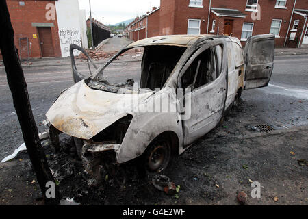 A burnt out car on the Donegall road in west Belfast after a night of sporadic rioting, which saw Nationalists attack police in west Belfast. Stock Photo