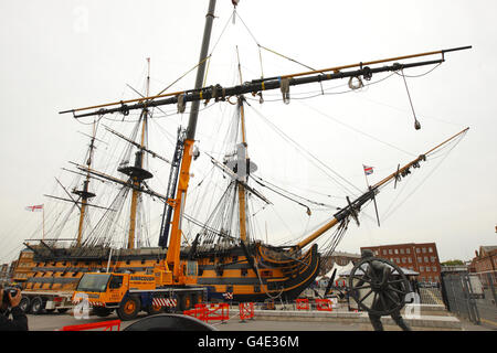 Engineers remove the yard arms from the foremast Admiral Lord Nelson's flagship, HMS Victory, at the Royal Navy Dockyard in Portsmouth, during her most extensive restoration project since she was repaired following the Battle of Trafalgar in 1805. Stock Photo