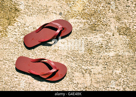 Photograph of a pair of red sandals on a wet floor Stock Photo