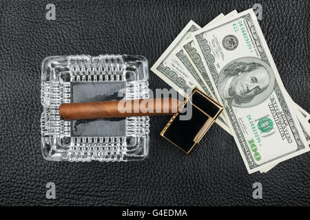 Cigar, ashtray, lighter, money on genuine leather, can be used as background Stock Photo