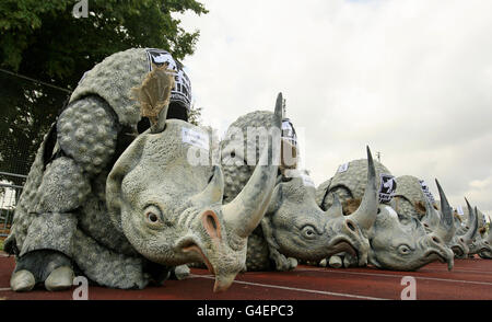 Runners dressed in rhino costumes take part in a 100 metre sprint, organised by Save the Rhino International, at Mile End Park Stadium, east London, to highlight the work of the charity, which conserves populations of critically endangered rhinos in Africa and Asia. Stock Photo
