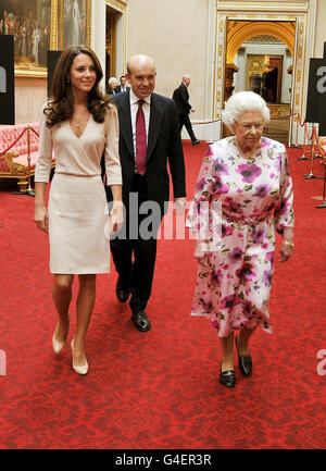 Britain's Queen Elizabeth II walks with the Duchess of Cambridge, as they view the exhibitions for the summer opening of Buckingham Palace in central London, this afternoon. Stock Photo