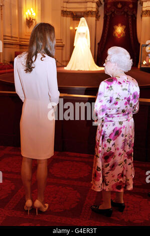 Britain's Queen Elizabeth II talks with the Duchess of Cambridge as they view the wedding dress she wore during her April marriage to Prince William, at Buckingham Palace in central London, this afternoon. Stock Photo