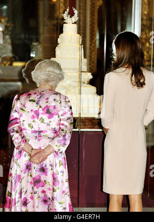 Britain's Queen Elizabeth II pictured with the Duchess of Cambridge as they view the wedding cake handmade for her April marriage to Prince William, at Buckingham Palace in central London, this afternoon. Stock Photo