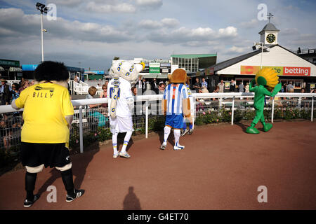 Burton Albion mascot Billy Brewer (left), Leeds United Lucas the Kop Cat (2nd left), Colchester United mascot Eddie the Eagle and Help the Hospices mascot Sunny the Sunflower make their way around the parade ring at Uttoxeter Racecourse Stock Photo