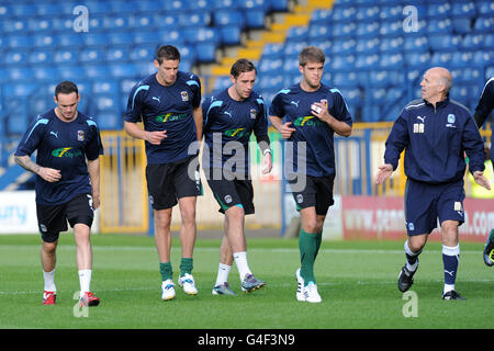 Coventry City players warming up before the match with Coventry City fitness coach Mick Rathbone (far right) Stock Photo