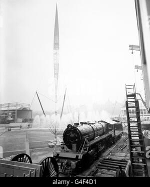 Finger of the future, the Skylon rears above it's earthbound attendant fountains and a giant locomotive in this Festival of Britain preview on the South Bank Exhibition site. The fountains, being fully tested for the first time, flank the base of the 290ft high Skylon. The 173 ton locomotive was built in Glasgow for the Indian Government Railways and is being shown at the Exhibition before going overseas. Stock Photo