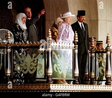 The Duke of Edinburgh (left) points while chatting to the Sultan of Brunei's First wife, during the official welcoming ceremony, at the start of the Queen's state visit. Her Majesty the Queen stands with the Sultan Brunei. Stock Photo