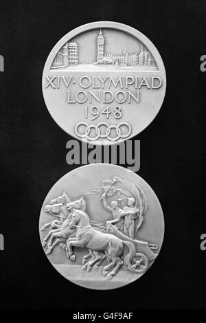 Participation Medals for the competitors at the 1948 London Summer Olympic Games. Made from oxydiced silver instead of gold, 51,0 mm in diameter and weighing 61 gr. Design by B. Mackennal and J. Pinches. The Obverse shows a City view of London over legend in three lines with the Olympic rings below. The reverse depicts a symbolic Grecian chariot. 4,062 competitors will take part in the Olympics. Stock Photo