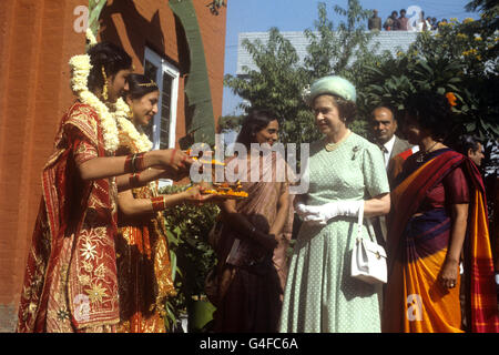 The Queen is offered food by girls in traditional Indian dress at the Mahatma Gandhi memorial at Raj Ghat, Delhi. Gandhi was cremated here following his assassination. This was the Queen's second visit to the site, the first was in 1961 when she planted a tree. Stock Photo