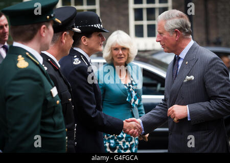 The Prince of Wales and the Duchess of Cornwall are greeted by (from the right) Assistant Commissioner Lynne Owens (Met Police), Assistant Commissioner Jim Knighton (London Fire Brigade) and Assistant Commissioner Jason Killens (London Ambulance Service) during a visit to the Metropolitan Police Central Communications Command, London, where the emergency services responded to last weeks riots in London. Stock Photo