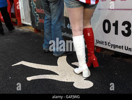 Soccer - Carling Cup - Second Round - Exeter City v Liverpool - St James' Park. Exeter City raffle ticket seller wears red and white boots before the Carling Cup Second Round match at St James' Park, Exeter. Stock Photo