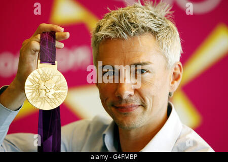 Former British Triple Jumper Jonathan Edwards with the 2012 Olympic Gold Medal during a photocall at the London Organising Committee of the Olympic Games 2012 in Canary Wharf, London. Stock Photo