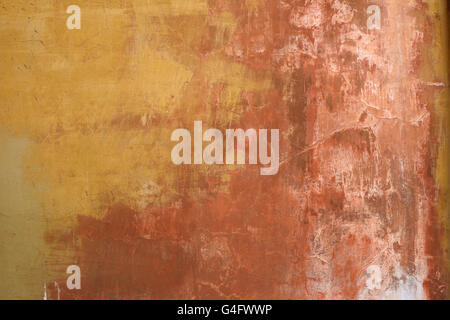 Old weathered and worn stucco wall in ochre and earth colours background Stock Photo