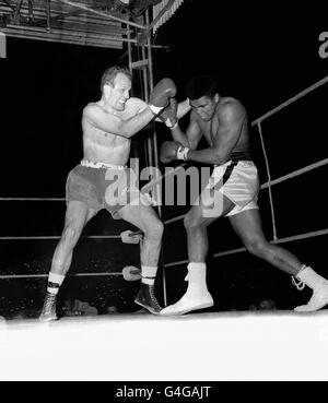 British boxer Henry Cooper (left) challenging World Heavyweight boxing Champion Cassius Clay (later Muhammad Ali), during the first round of their fight at the Arsenal Stadium, London. 12/12/99: Ali named 'Sports Personality of the Century'. * ...by viewers of BBC television television's Sports Personality of the Year programme. *17/01/02: Ali celebrates his 60th birthday. Stock Photo