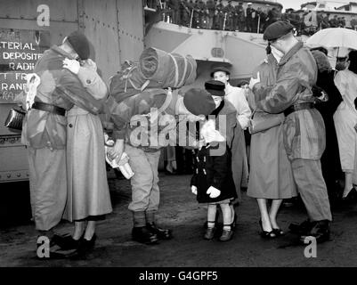 Jacqueline greets her father, Colour-Sergeant Berkeley of the Royal Marines Commando, when he returned to Plymouth from Port Said, Egypt. He and other Marines were on board the Light Fleet Carrier HMS Ocean. Other members of the Commando greeting their wives are DJ Crewe of Portsmouth (left) and G. Rollinson from Liverpool. Stock Photo