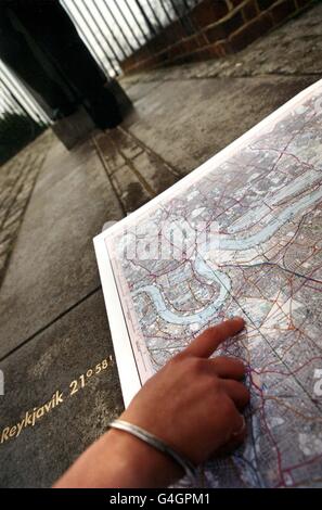 The Hand of Time : Maria blyzinsky, the Curator of Astronomy at the Royal Observatory in Greenwich, indicates the route of the Greenwich Meridian as it will appear on a series of detailed Ordnance Survey Explorer maps. The photograph was taken on the famous brass 'time line' at the Observatory in Greenwich, but the 17 maps will allow people to celebrate the start of the new millennium at any point along the meridian as it runs through Britain, Yorkshire and Sussex. 08/10/04: More than 200,000 children may miss out on getting free maps of their home areas worth 7 each because their teachers Stock Photo