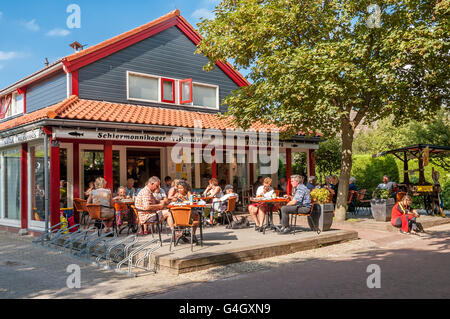 People enjoying meal on outdoor terrace of fish and chips restaurant on the West Frisian island Schiermonnikoog, Netherlands Stock Photo