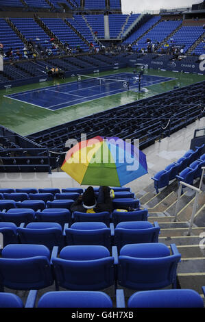 Tennis - 2011 US Open - Day Ten - Flushing Meadows. Spectators sit under umbrellas as rain delays play during day Ten of the US Open at Flushing Meadows, New York, USA. Stock Photo