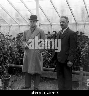 The Prince of Wales (later Edward VIII and Duke of Windsor) visiting the nursery of Mr Walter Burden, who is seen explaining the plants etc to the Prince. Stock Photo