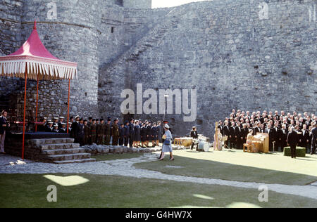 Queen Elizabeth walking to a dais at Harlech Castle, with a male voice choir in attendance. Stock Photo