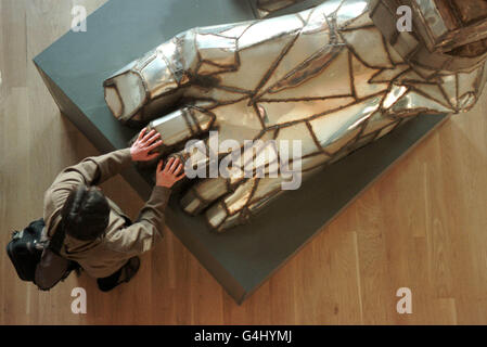 Man touches Paolozzi sculpture Stock Photo