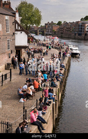 Lots of people drinking & relaxing at busy riverside pub (King's Arms) & leisure boats on River Ouse - King's Staith, York, North Yorkshire, England. Stock Photo